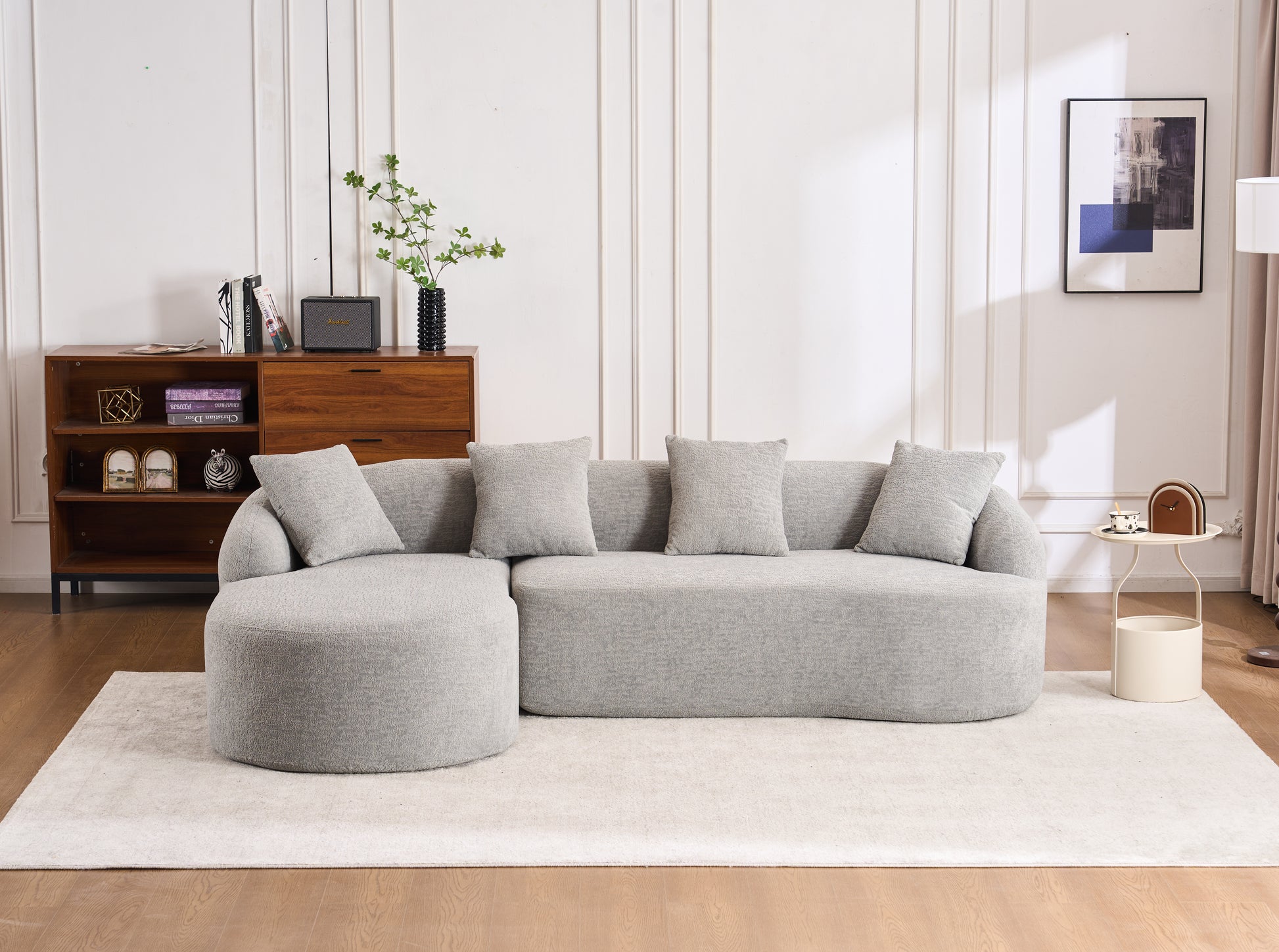 Grey textured fabric sectional sofa with rounded arms and plush pillows