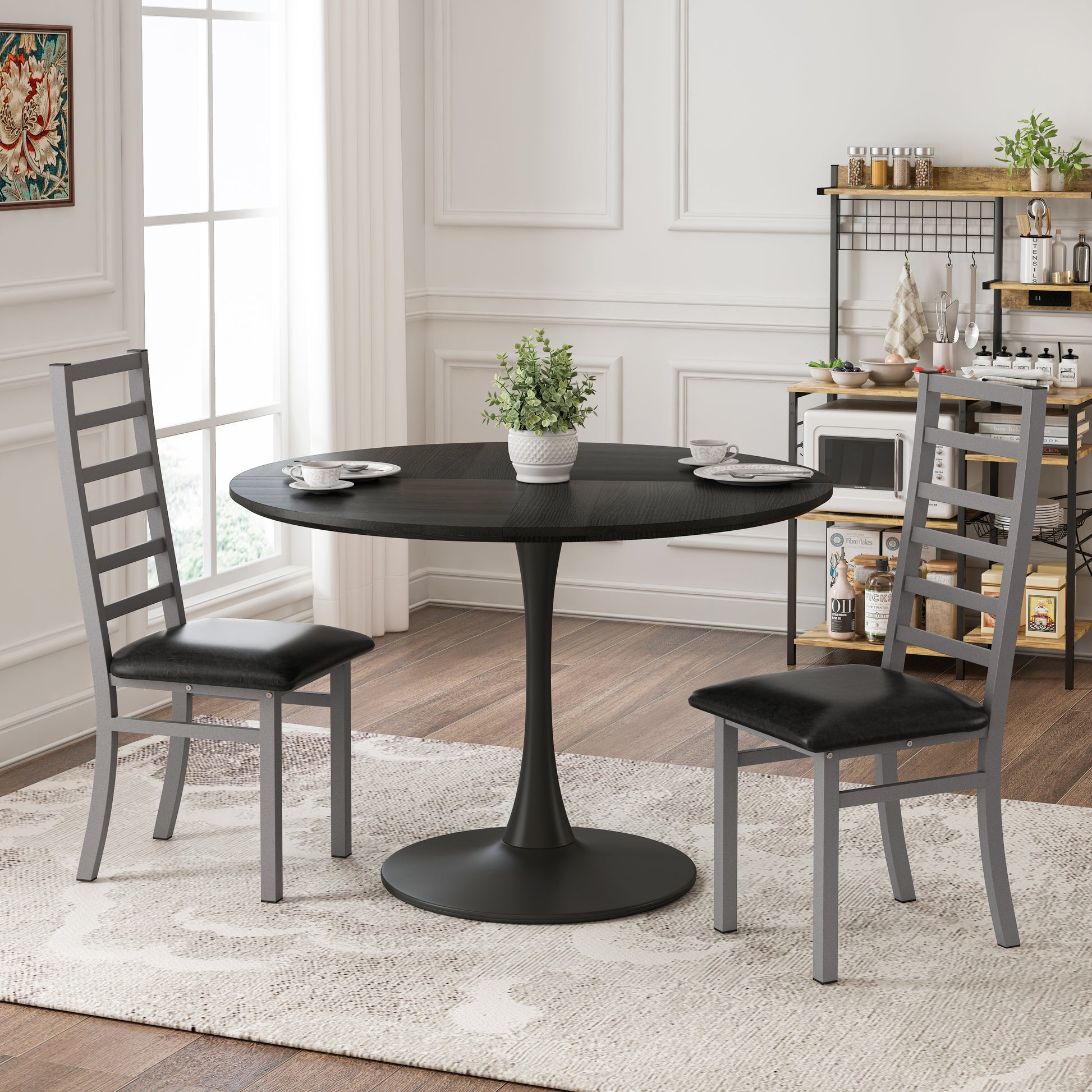 Black pedestal dining table with two modern grey chairs