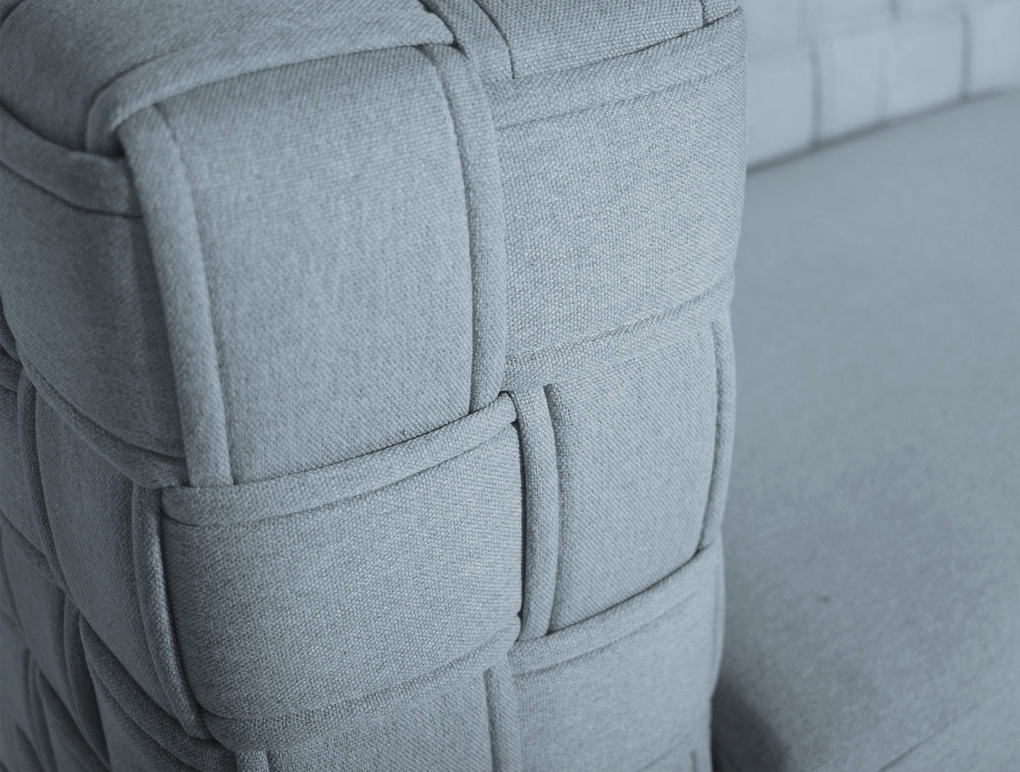 Closeup of grey woven fabric armchair armrest texture