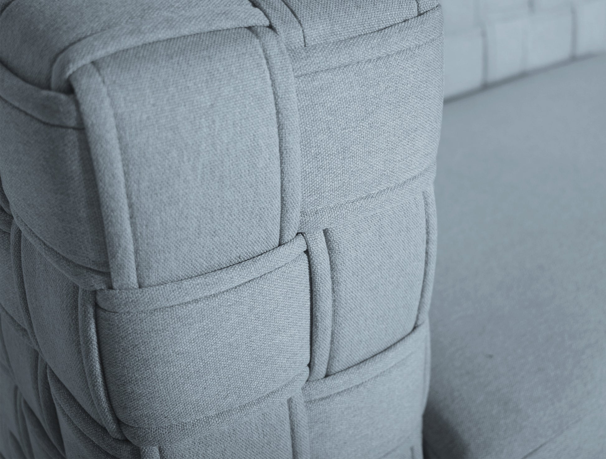 Closeup of grey woven fabric armchair armrest texture