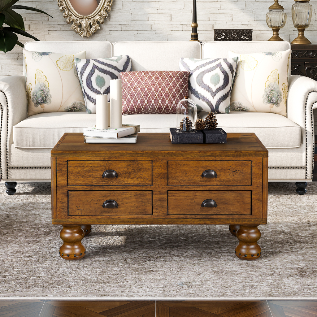 Rustic oak coffee table with four drawers and decorative metal pulls in a living room setting