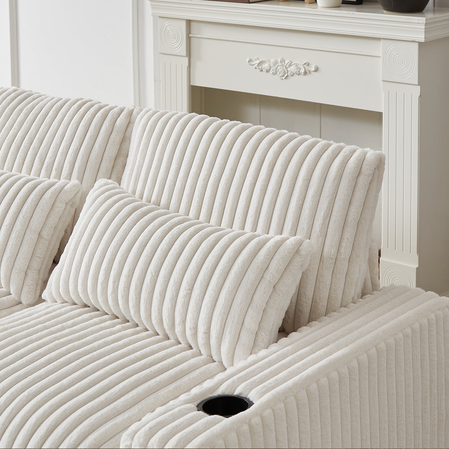 Cream corduroy sofa with plush throw pillows and builtin cup holder