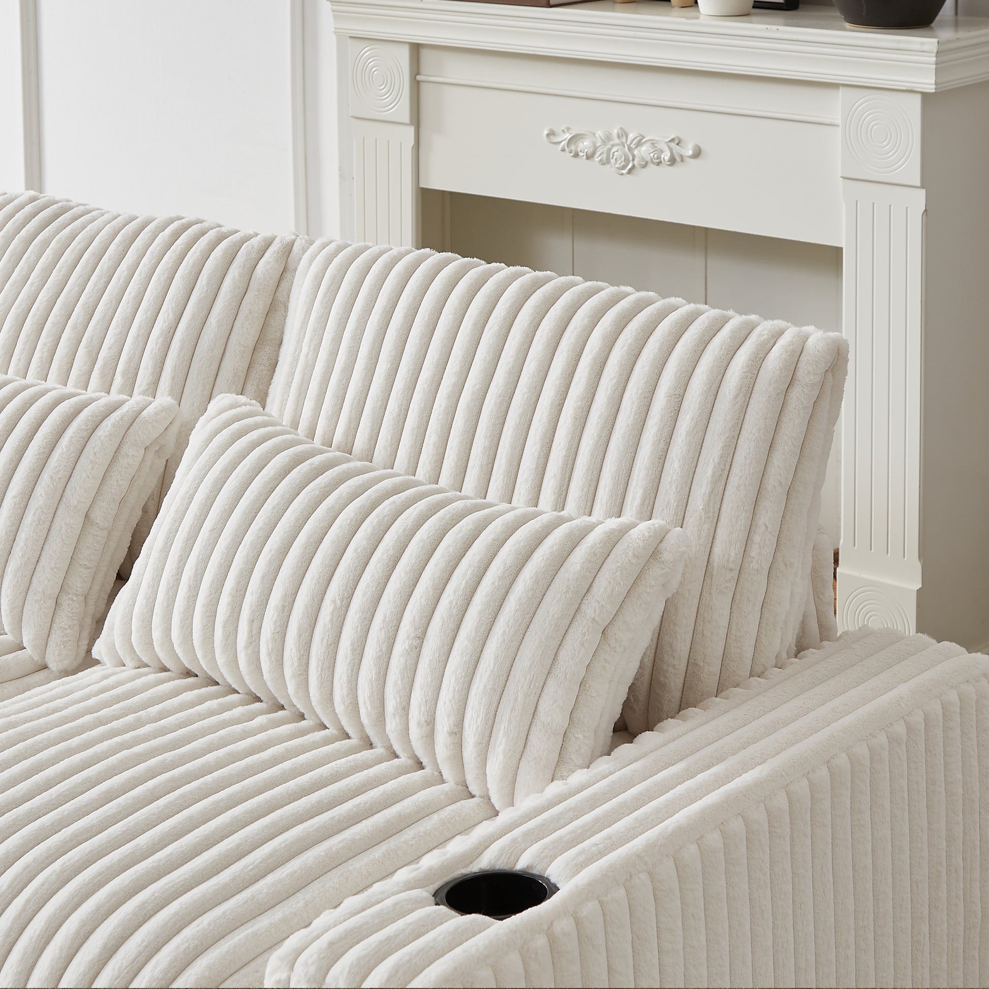 Cream corduroy sofa with plush throw pillows and builtin cup holder