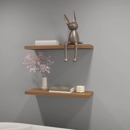 Silver metal bunny figurine perched on a modern wooden shelf
