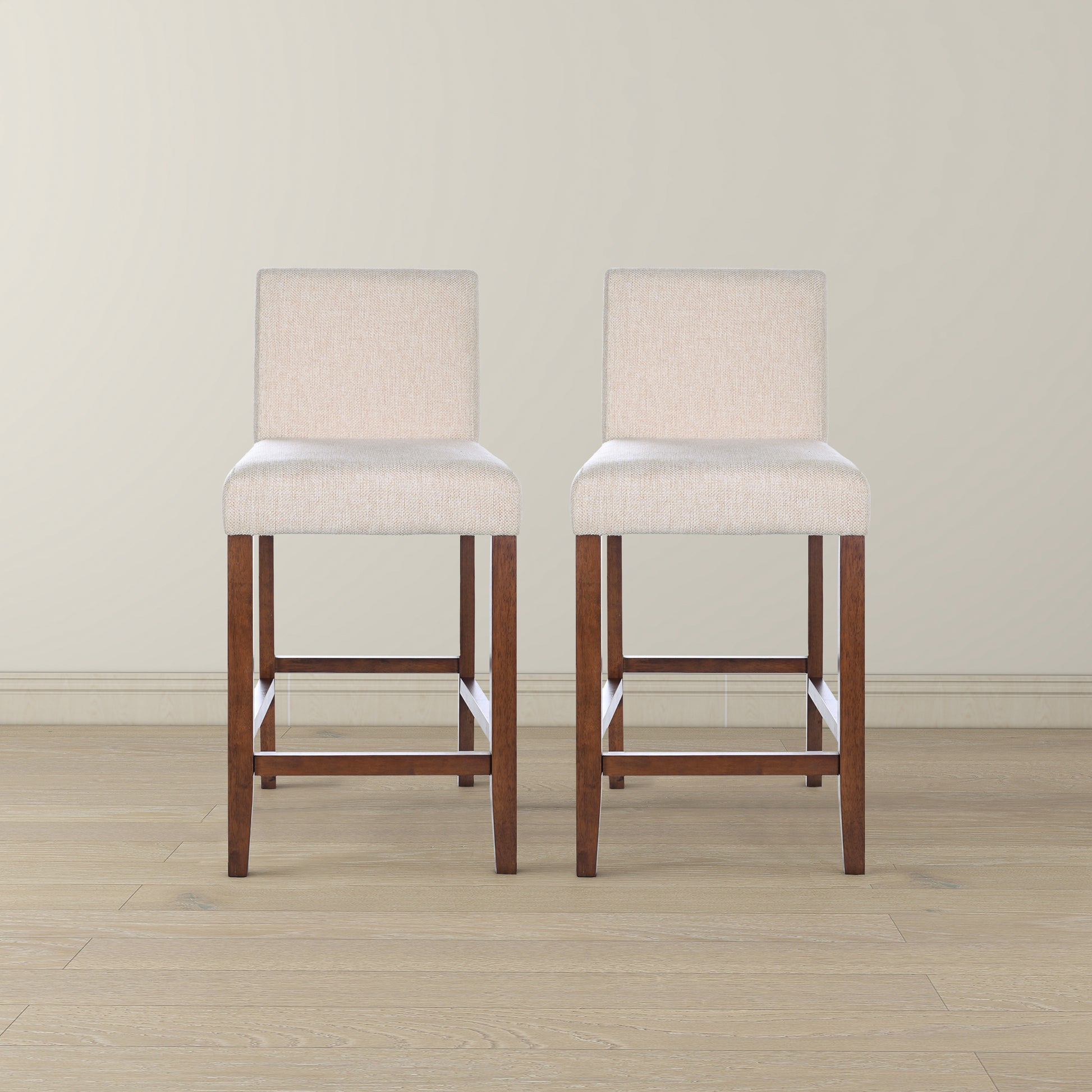Two upholstered beige bar stools with dark wood legs