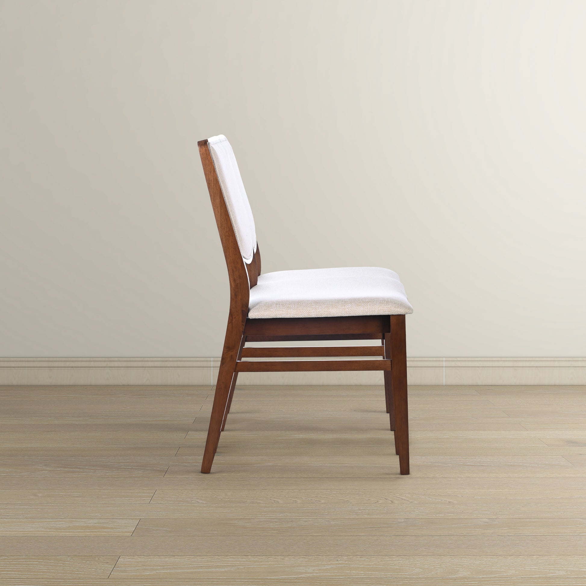 Side profile of a modern dark wood dining chair with a light beige upholstered seat and back