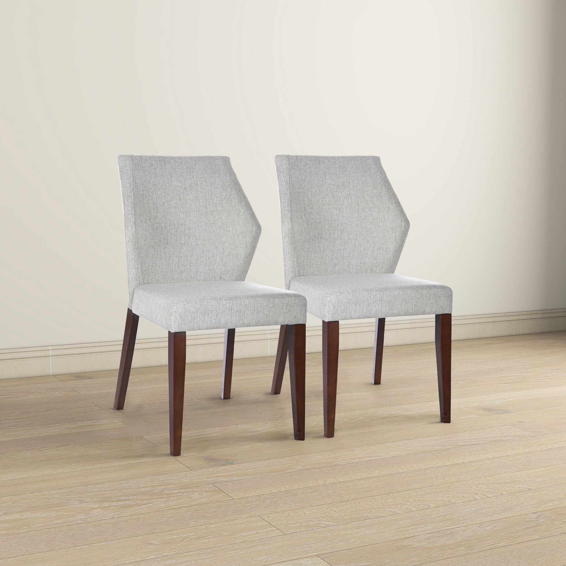 Two light gray fabric upholstered dining chairs with dark wood legs
