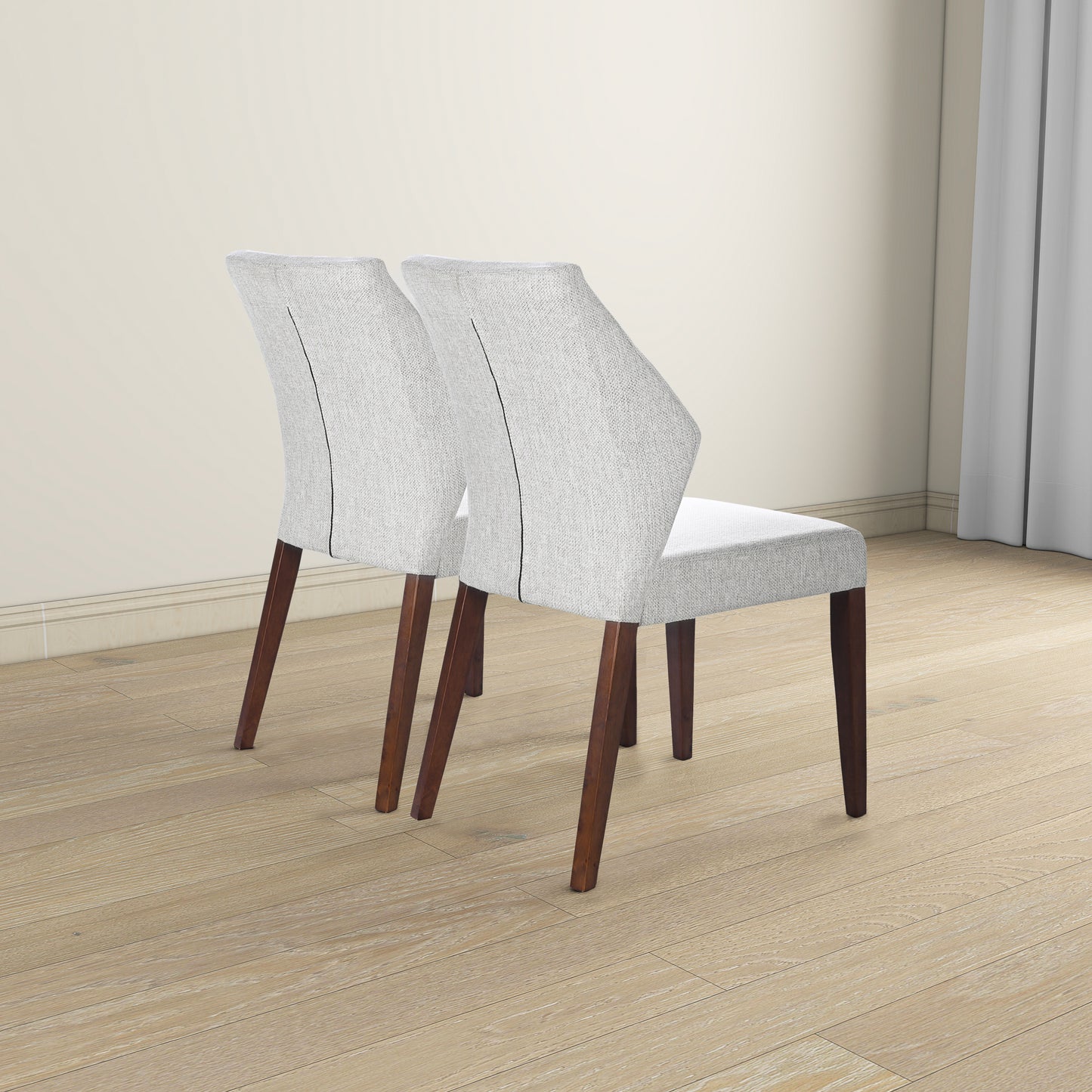 Two light gray upholstered dining chairs with dark wood legs and a black stitch detail