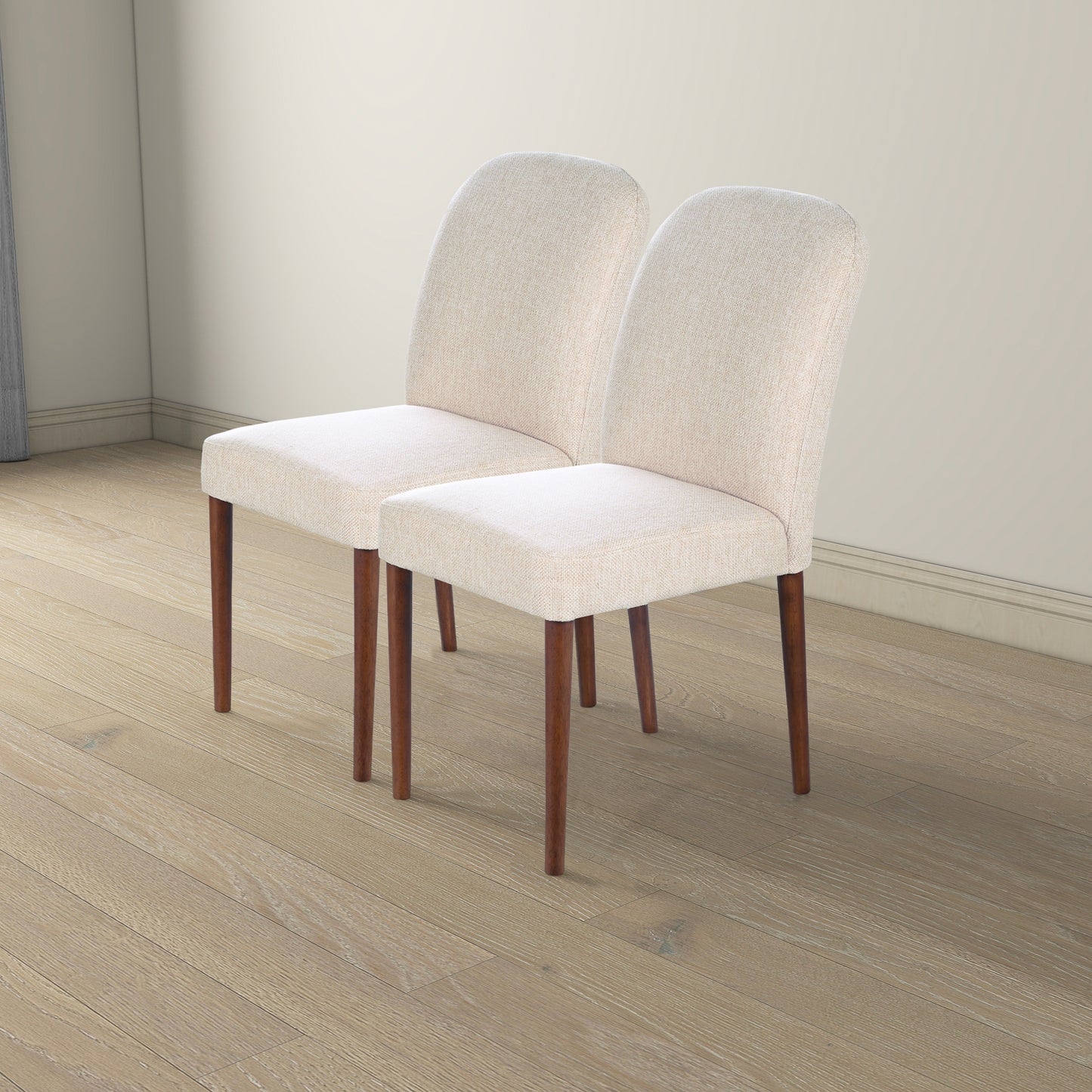 Two light beige upholstered dining chairs with tapered wooden legs