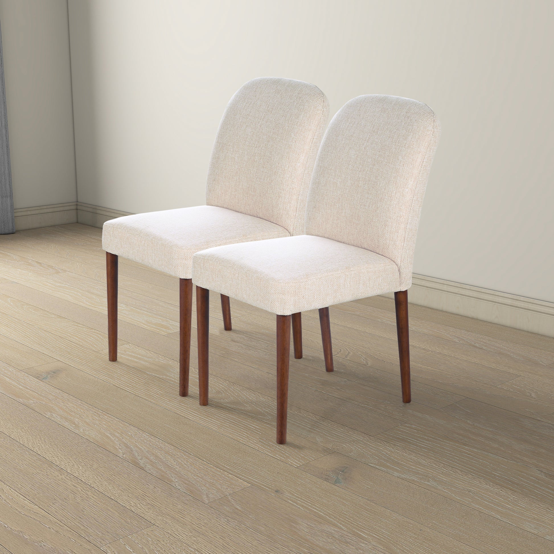 Two light beige upholstered dining chairs with tapered wooden legs