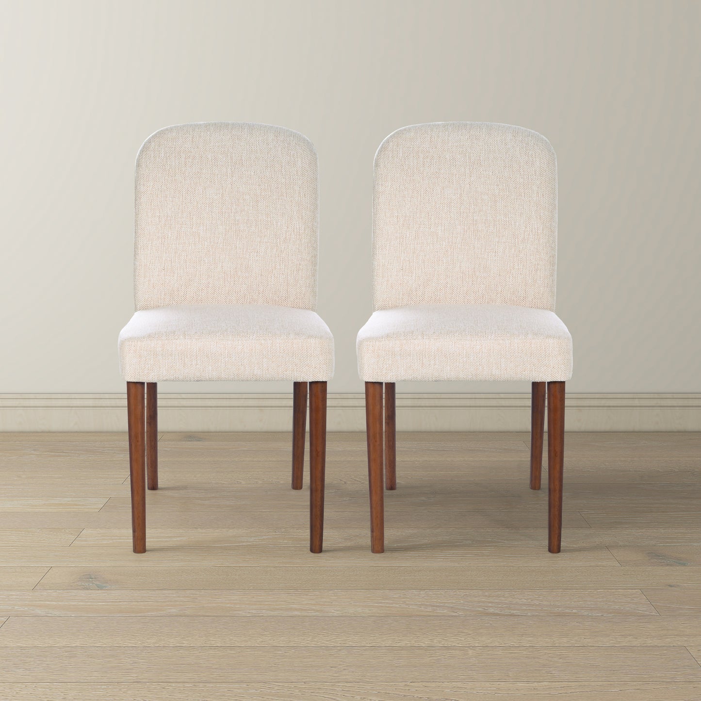 Two cream upholstered dining chairs with dark wood legs