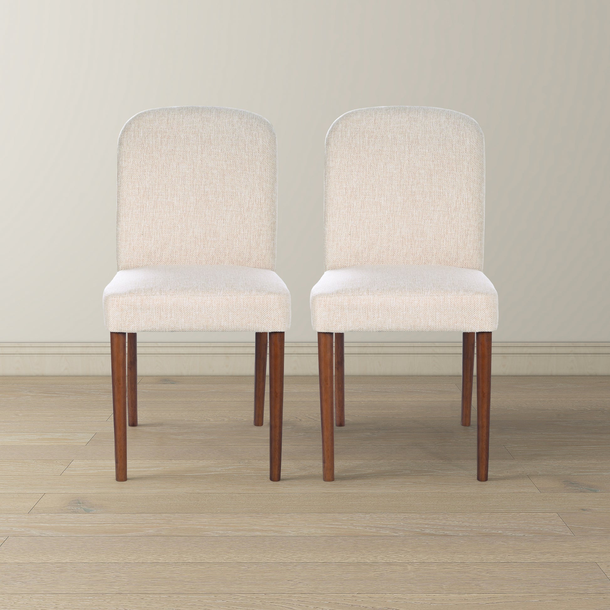 Two cream upholstered dining chairs with dark wood legs