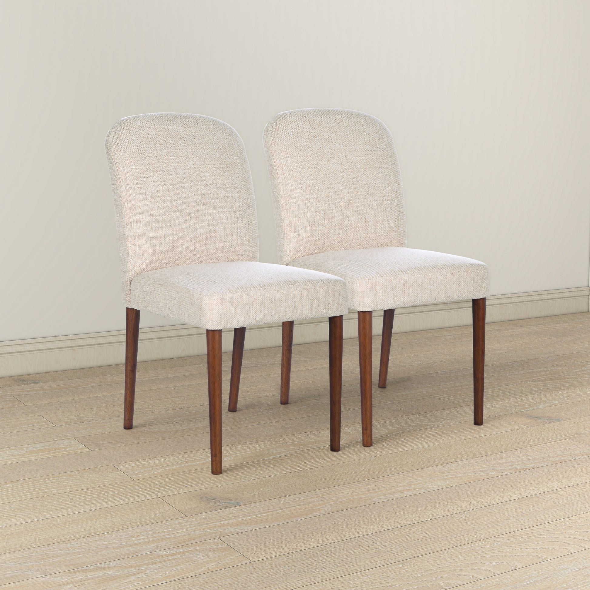 Two cream upholstered dining chairs with tapered wooden legs