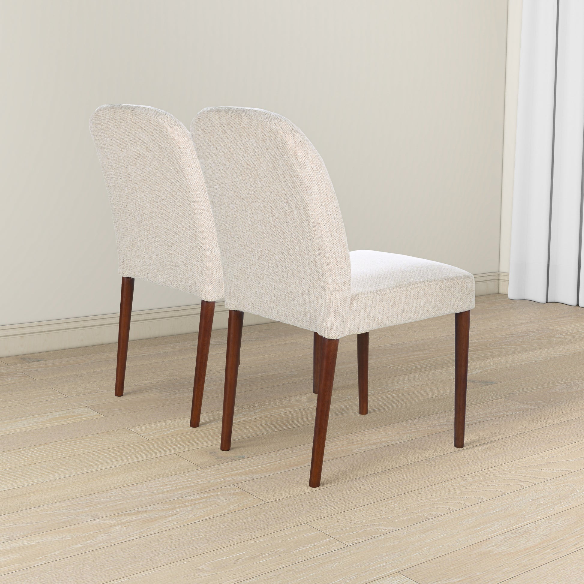 Set of two beige upholstered dining chairs with dark wood legs