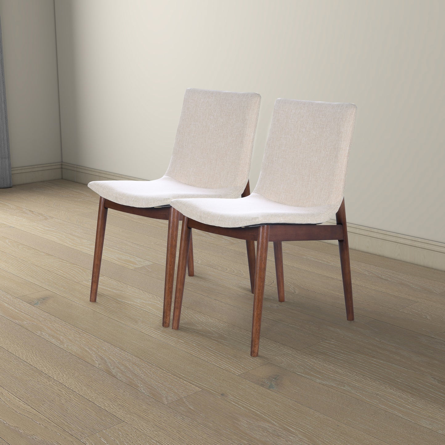 Two light beige upholstered dining chairs with walnut wood legs
