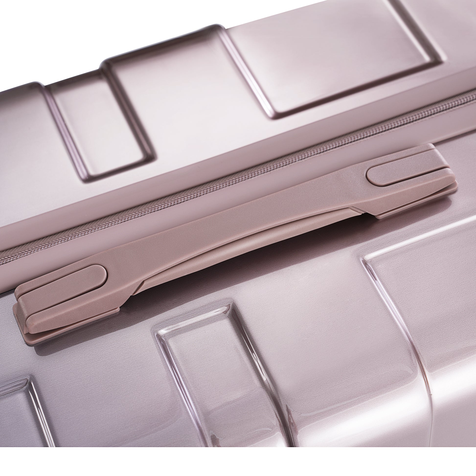 Closeup of a rose gold suitcase handle on textured metallic surface