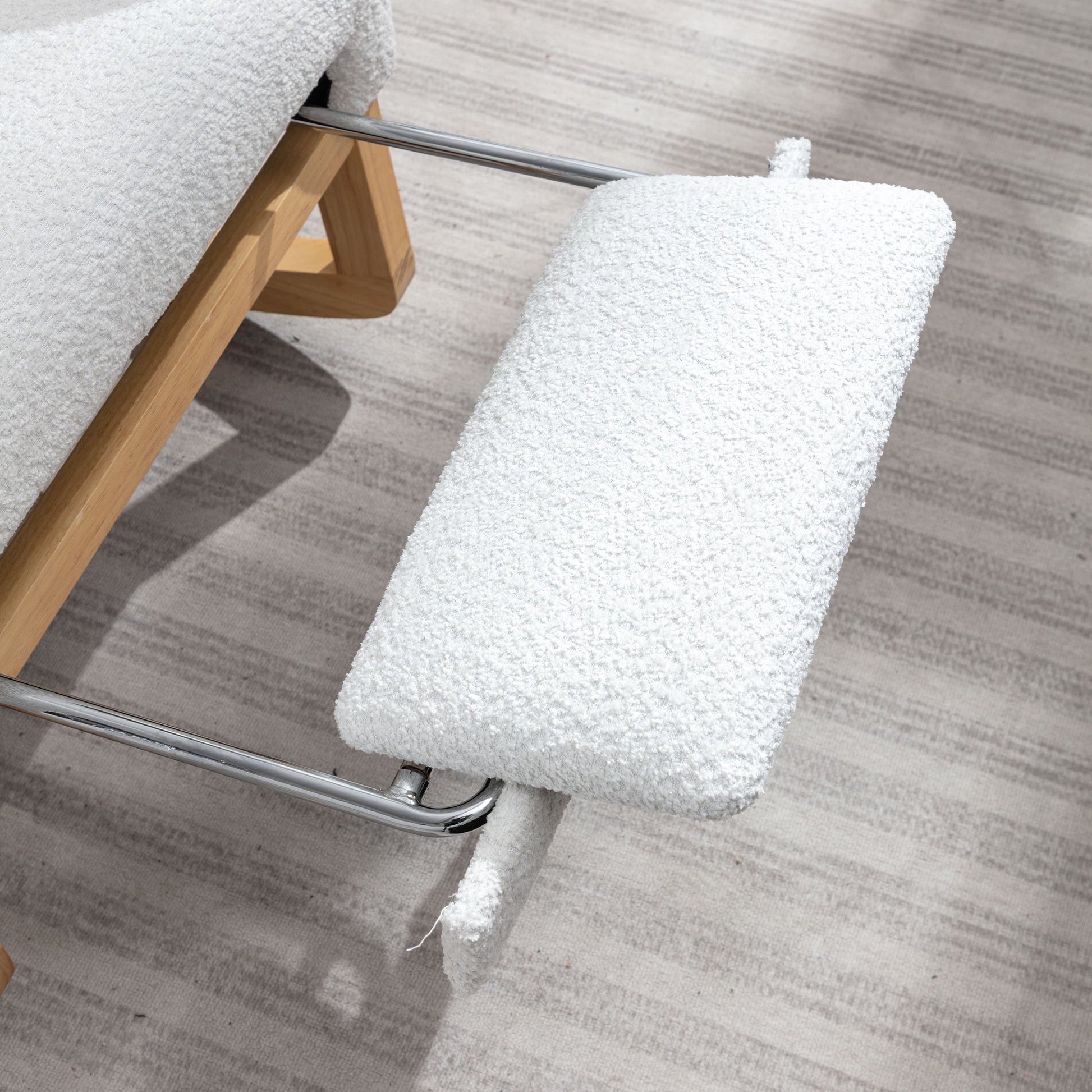 White boucle fabric ottoman with wooden legs and chrome accents