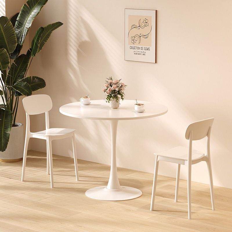White tulip dining table with two modern chairs