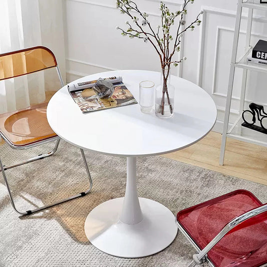 White round tulip table with vase and magazines
