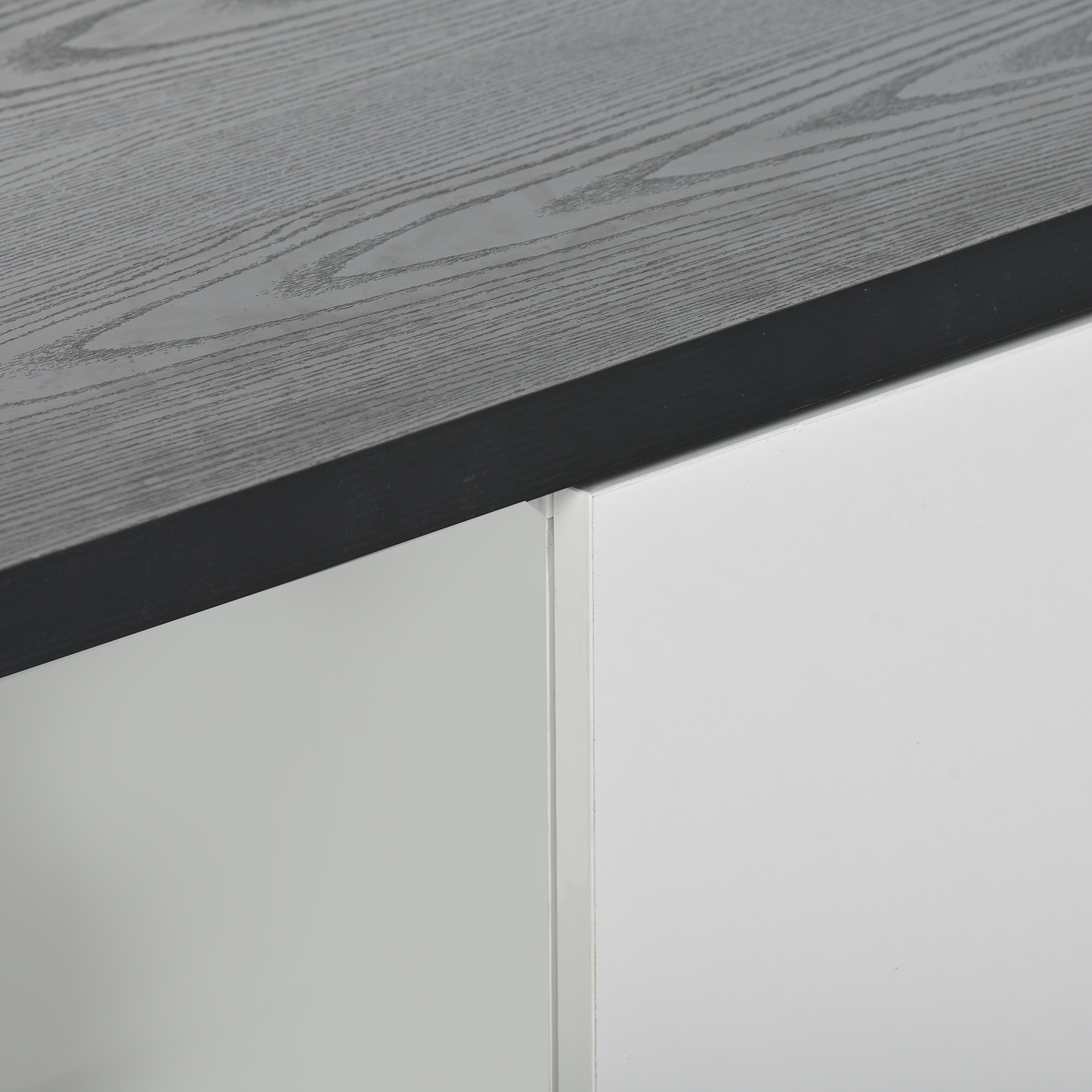 Closeup of dark grey wood grain tabletop with white cabinet panels