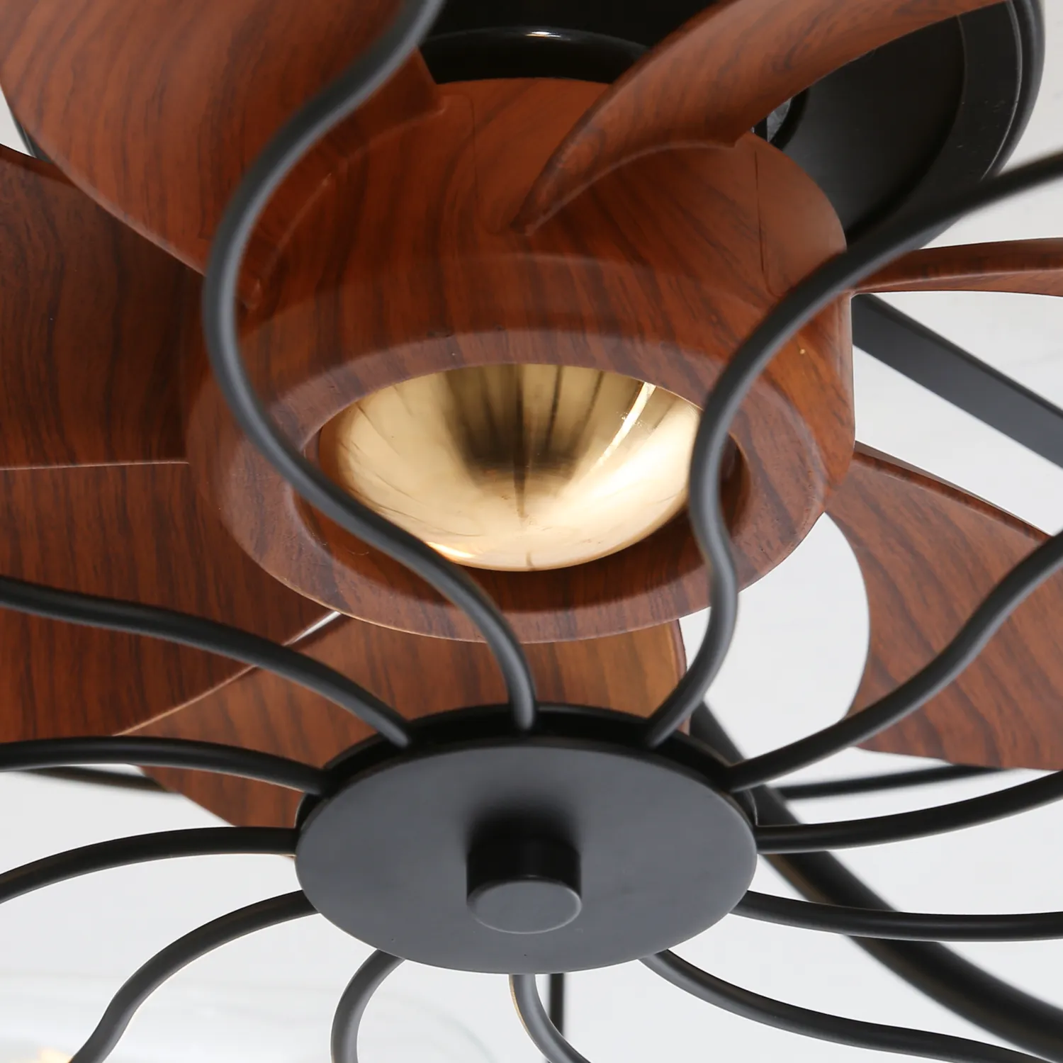 Closeup of a black ceiling fan with woodgrain blades
