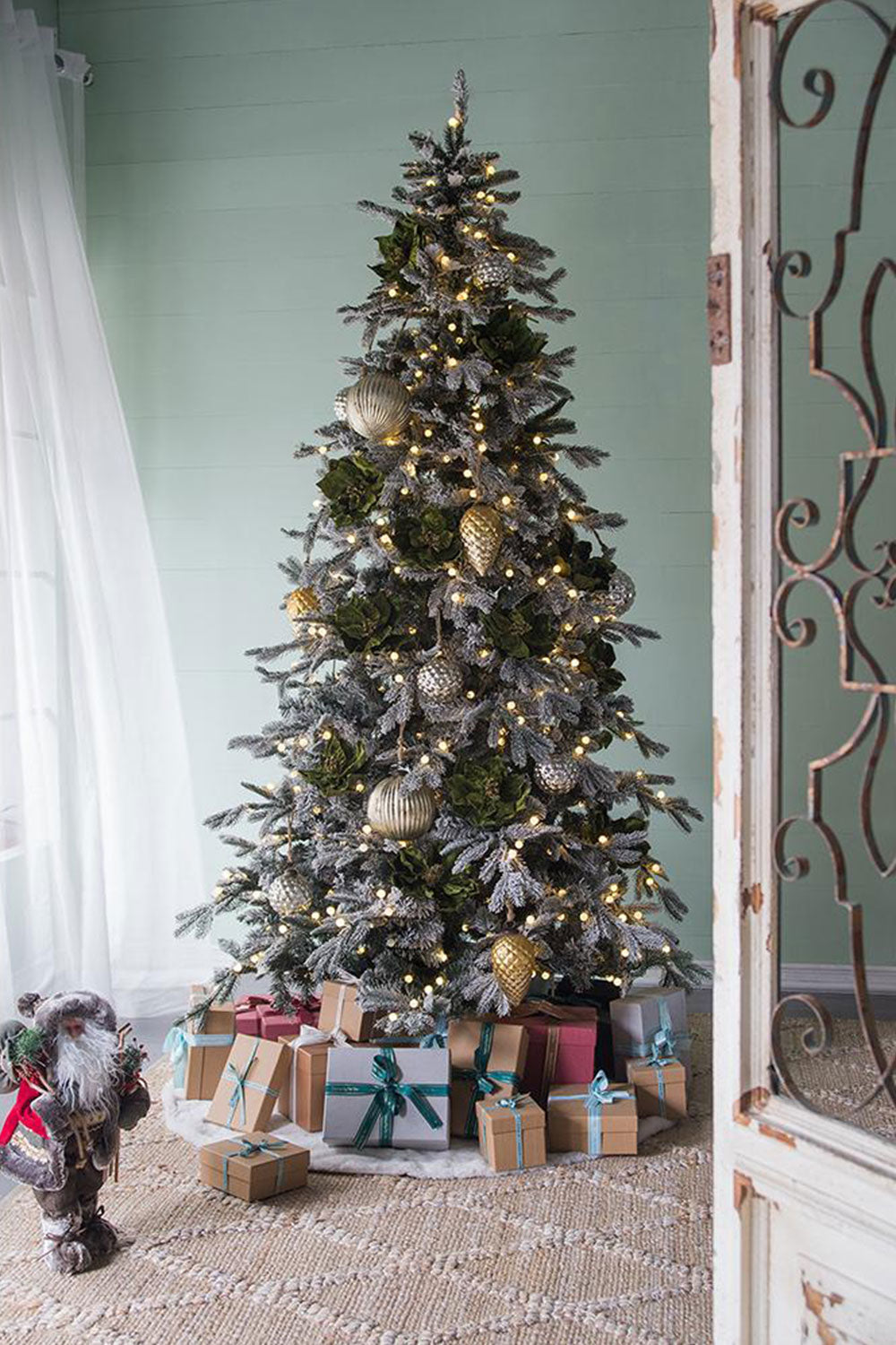 Flocked artificial Christmas tree with warm white LED lights and gold ornaments