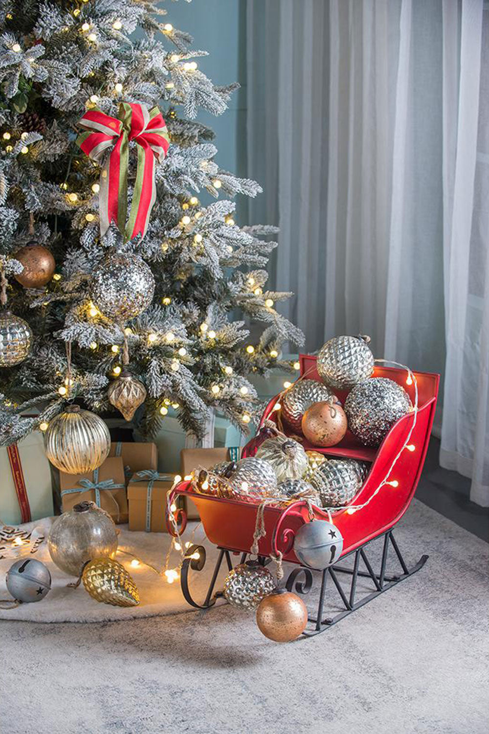Red sleigh filled with silver and gold Christmas ornaments