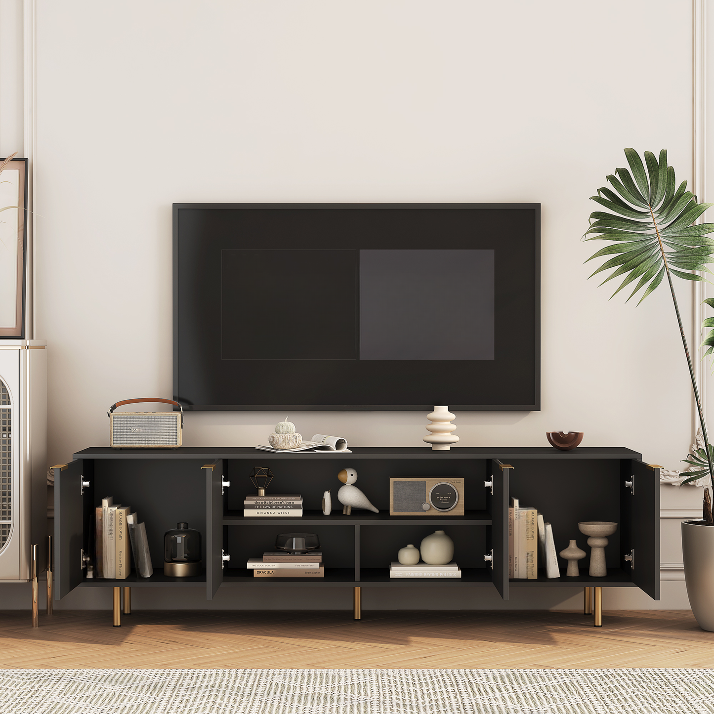 Dark grey modern TV stand with gold accents and open doors showcasing books