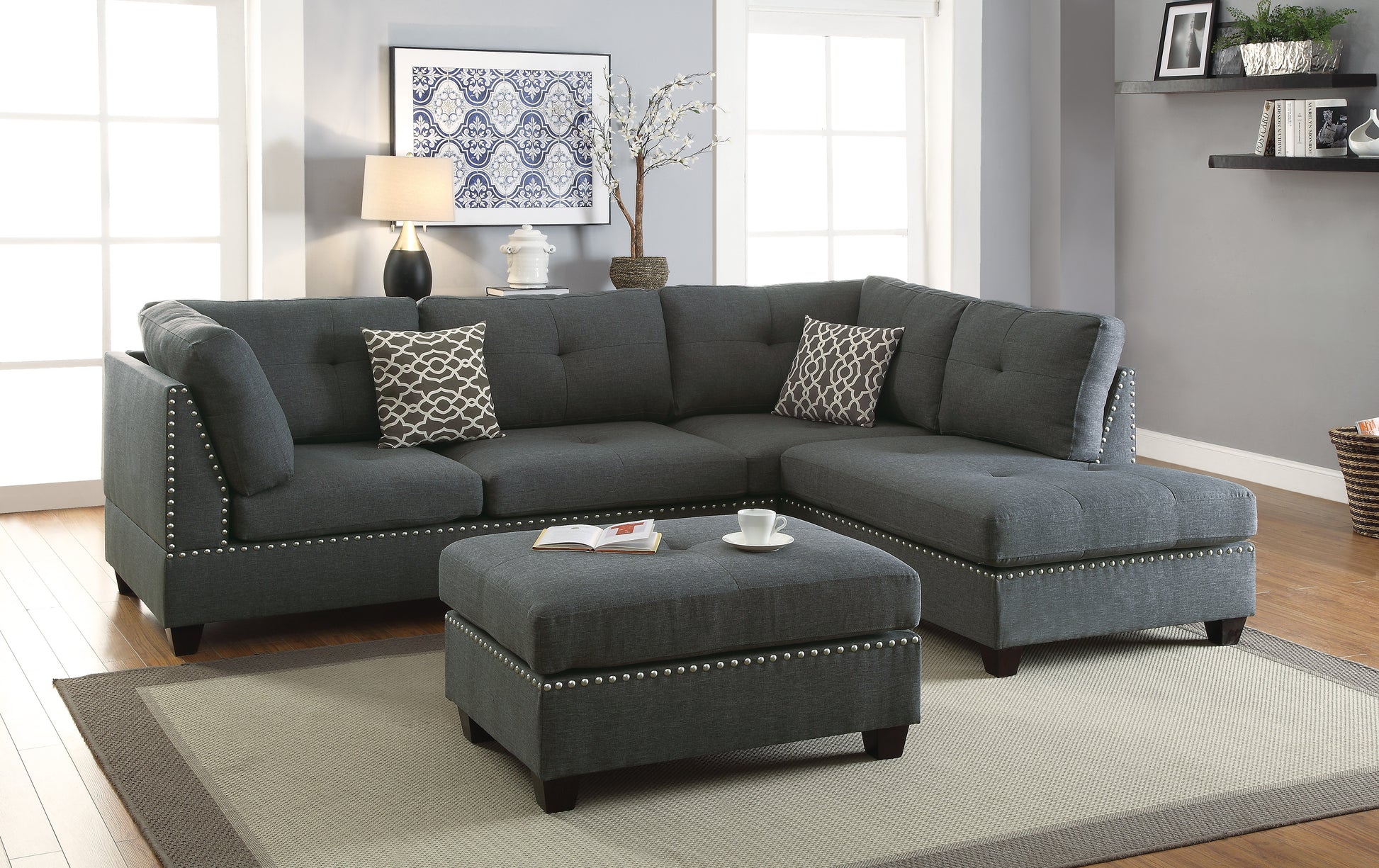 Dark gray fabric sectional sofa with tufted cushions and silver nailhead trim perfect for modern living rooms