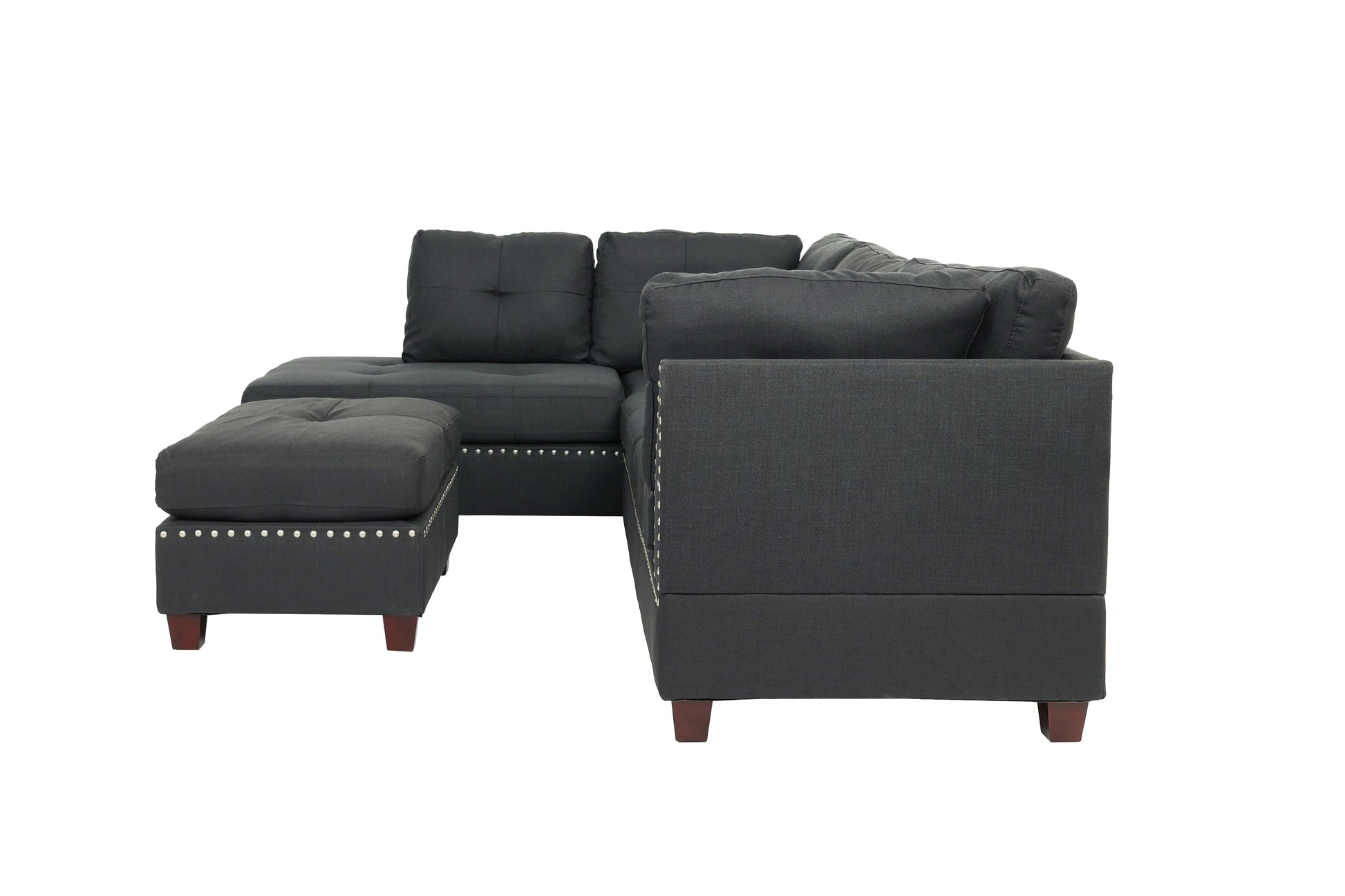 Dark grey fabric sectional sofa with tufted cushions and silver nailhead trim
