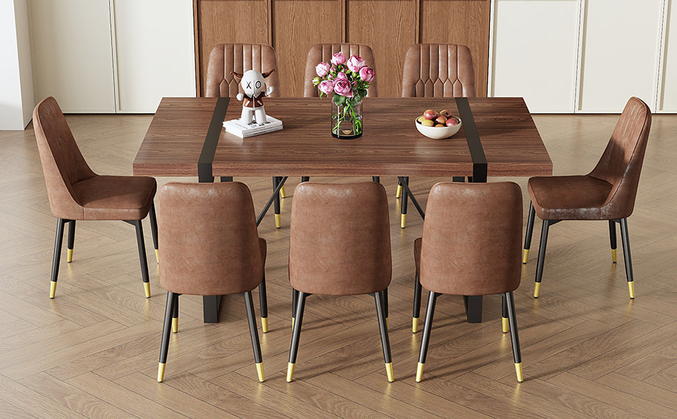 Brown faux leather dining chairs with gold accents and a walnut dining table