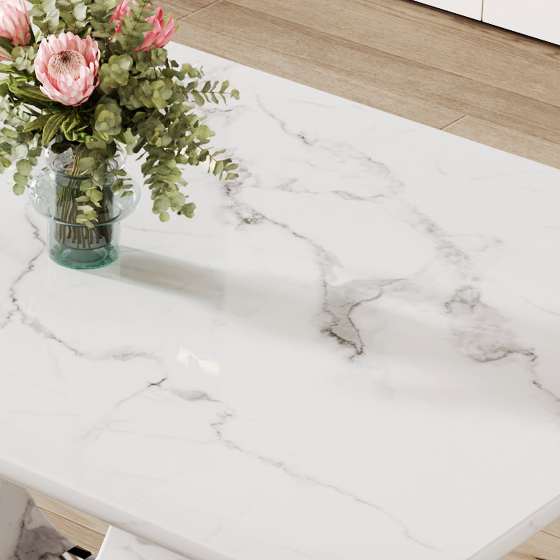 White marble coffee table with pink protea bouquet in glass vase