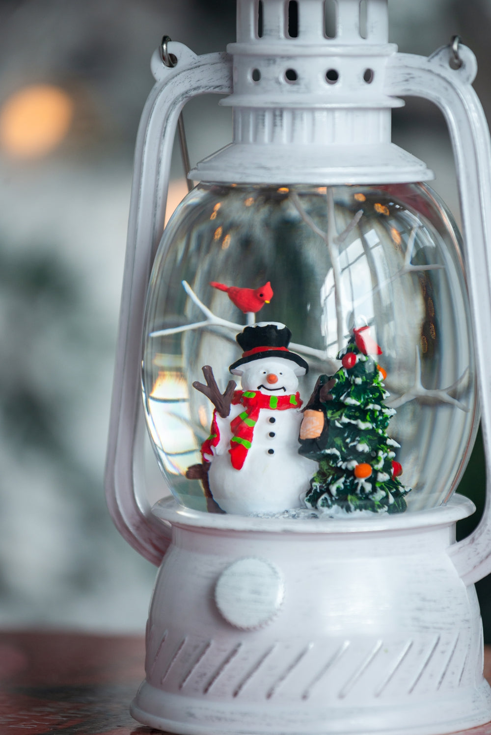 White vintage lantern snow globe with festive snowman and cardinal