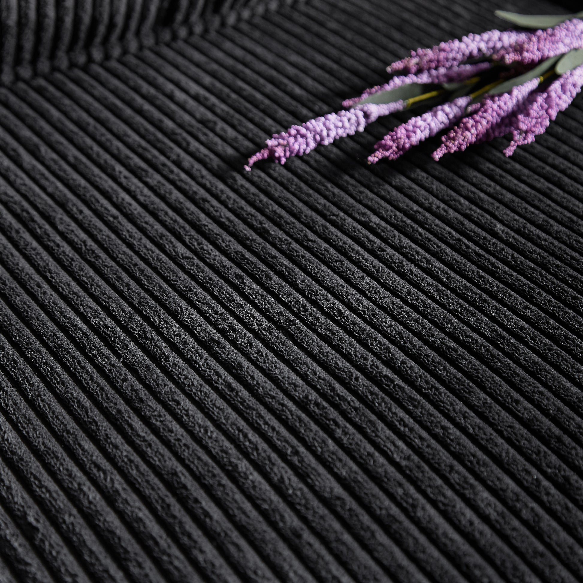 Closeup of ribbed black corduroy fabric texture