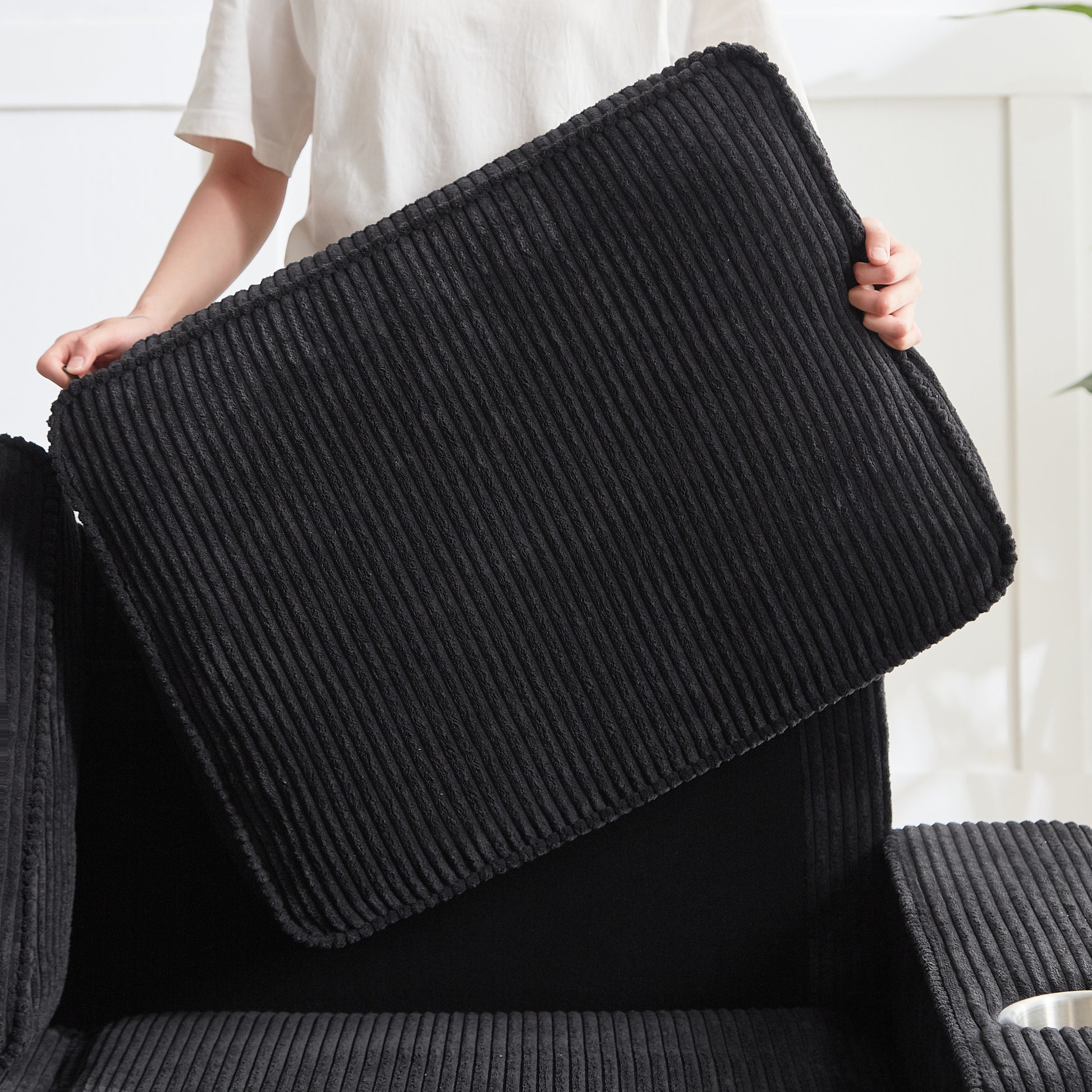 Black corduroy sofa cushion with ribbed texture