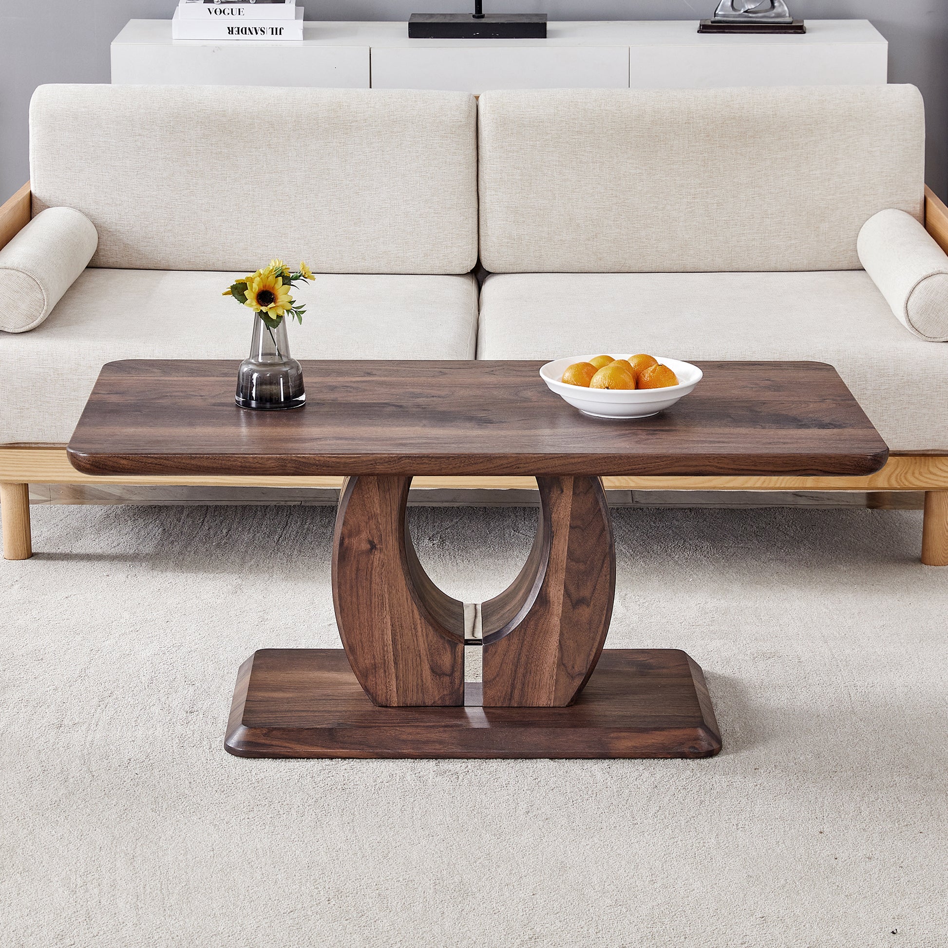 Dark walnut coffee table with rounded edges and sculptural base