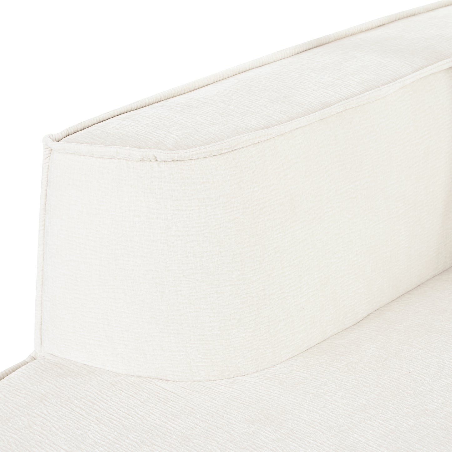 Closeup of plush cream upholstered armchair armrest with subtle textured fabric