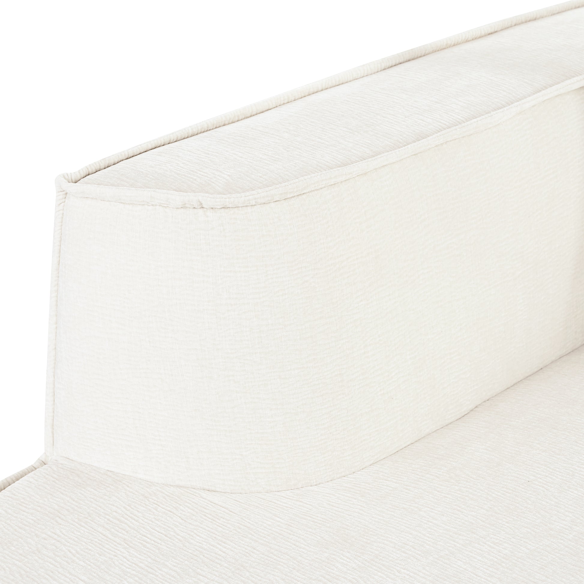 Closeup of plush cream upholstered armchair armrest with subtle textured fabric