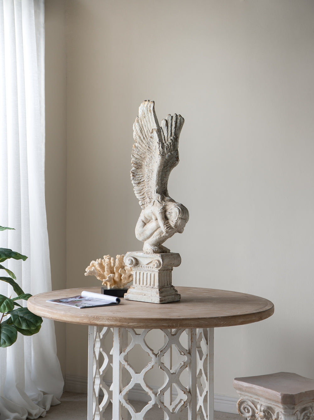 White distressed angel figurine on pedestal