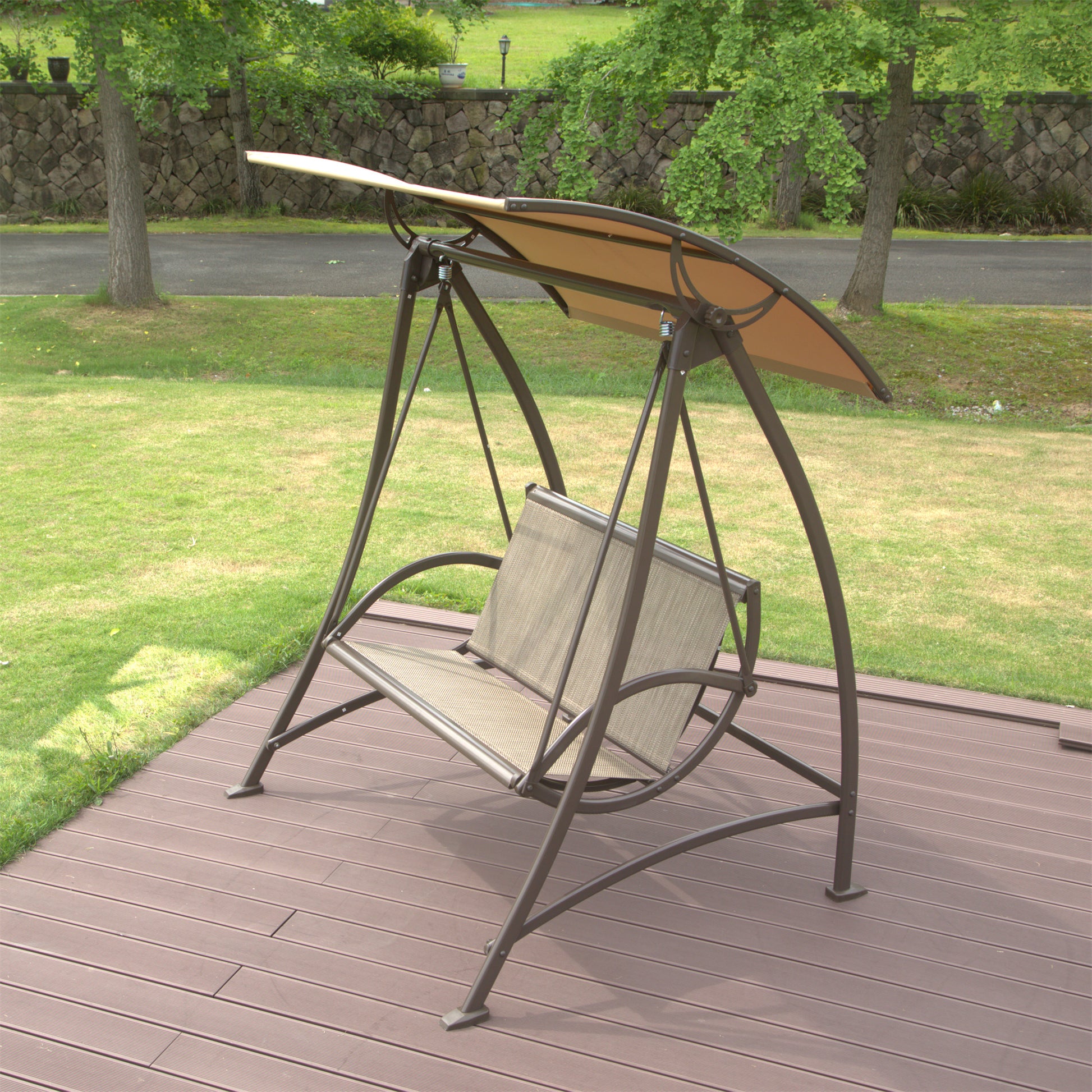 Bronze metal patio swing with beige fabric seat and canopy