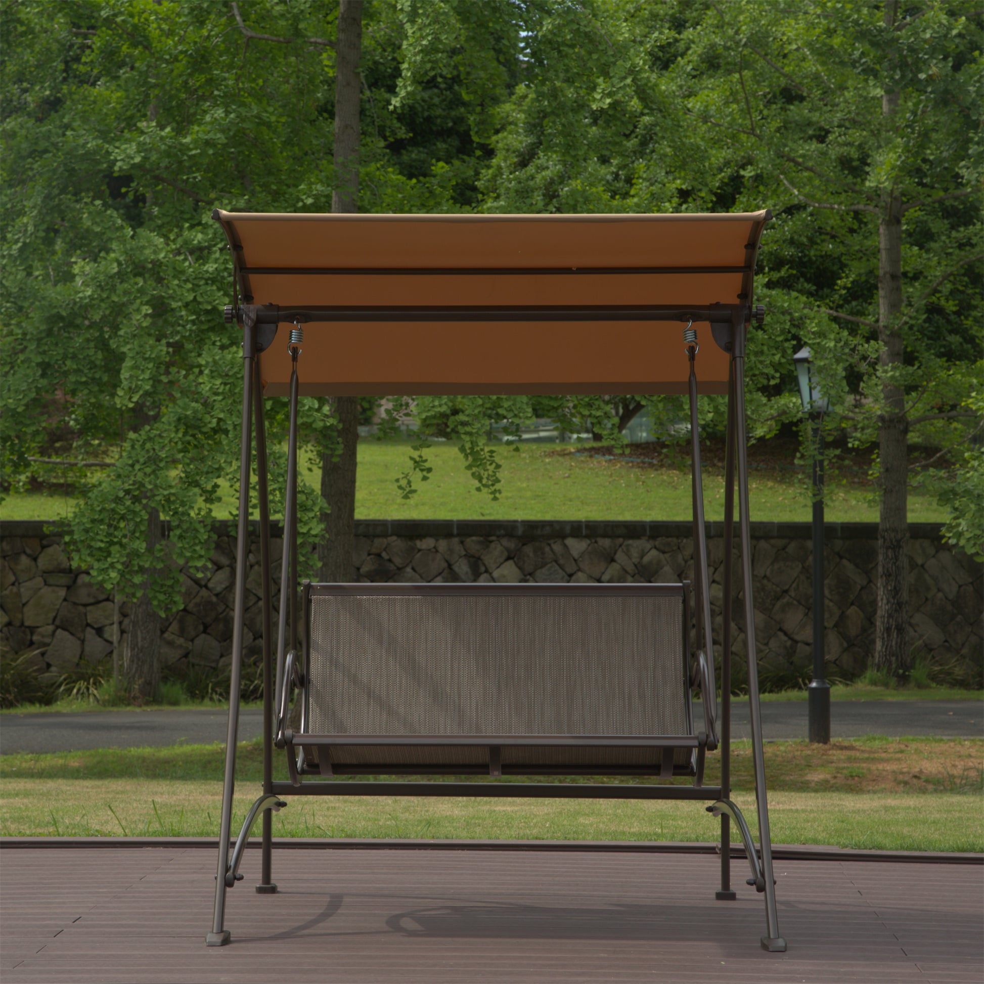 Metal patio swing with brown canopy and gray mesh seat