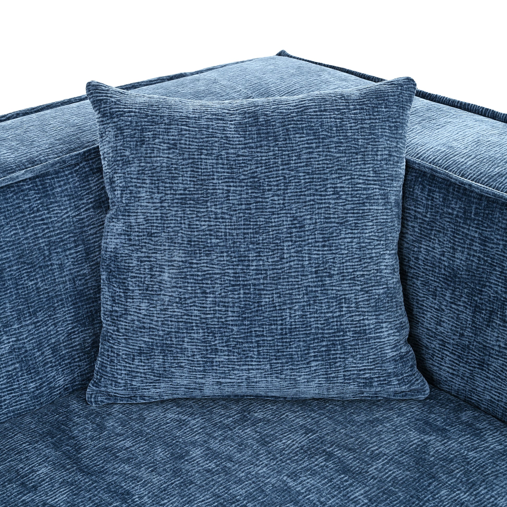 Textured blue velvet pillow on a matching sofa