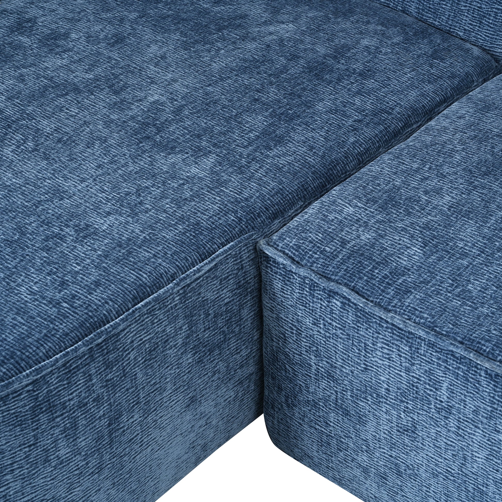Closeup of textured blue velvet fabric on a modern sofa corner