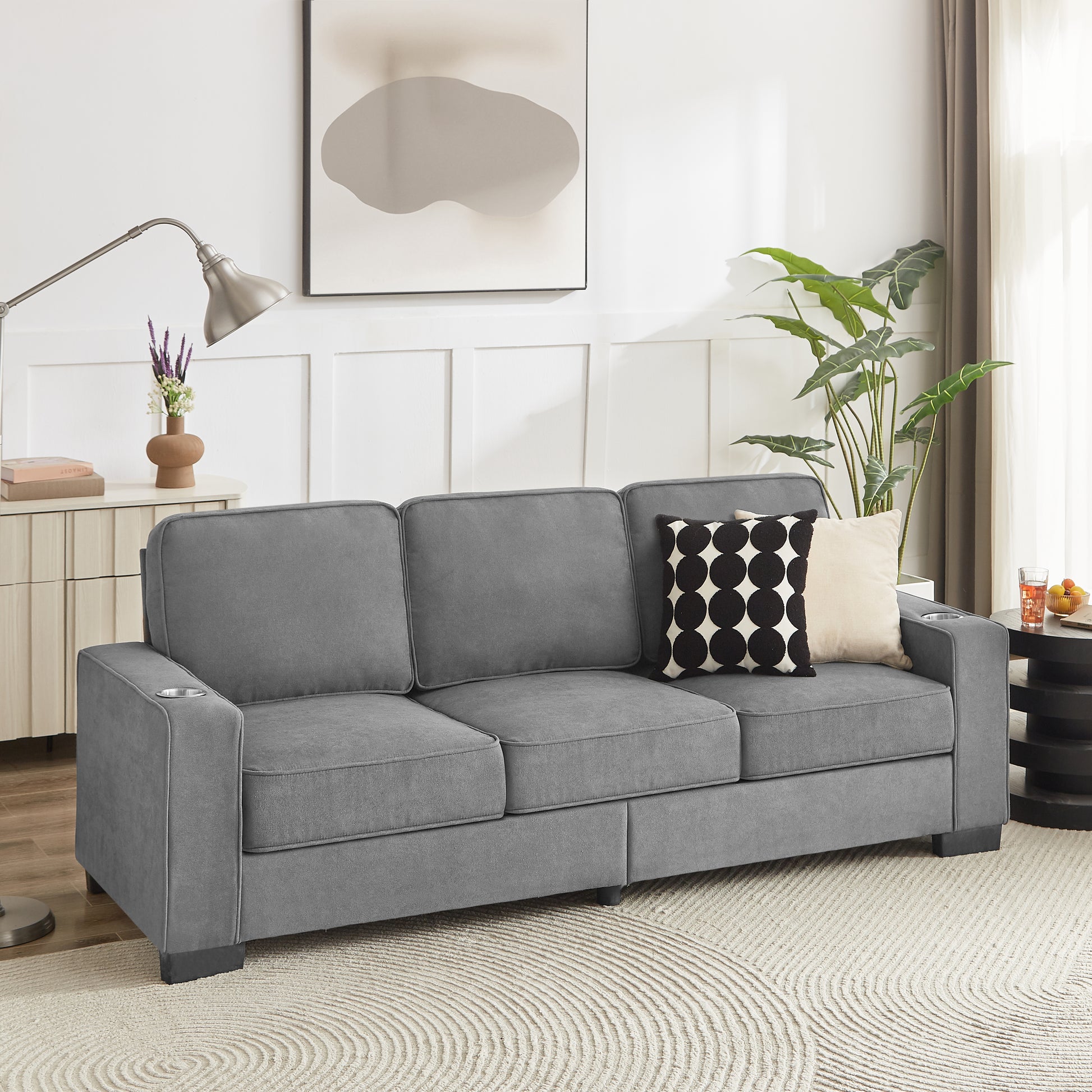 Gray fabric threeseater sofa with builtin cup holders on armrests