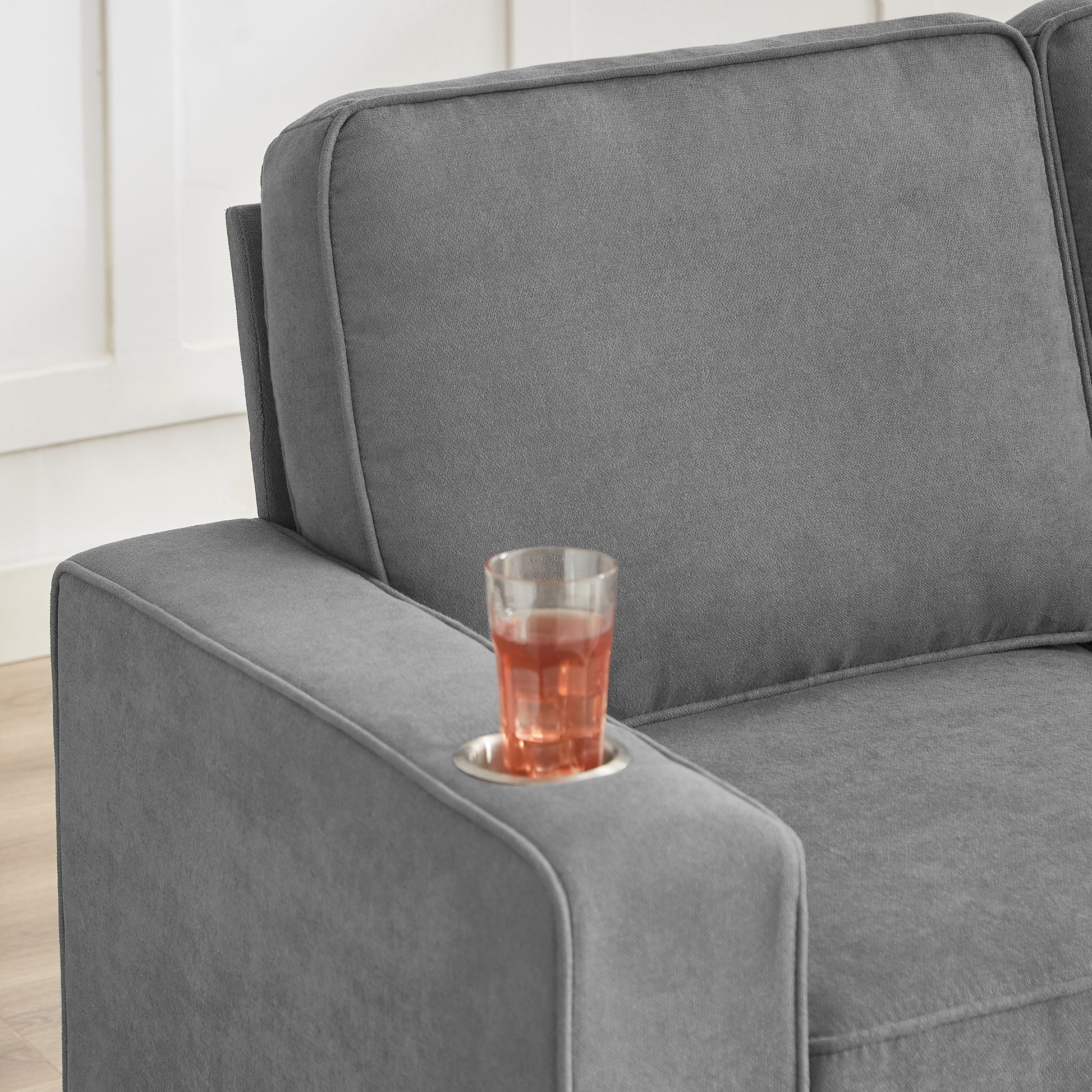 Gray upholstered sofa armrest with cup holder and beverage