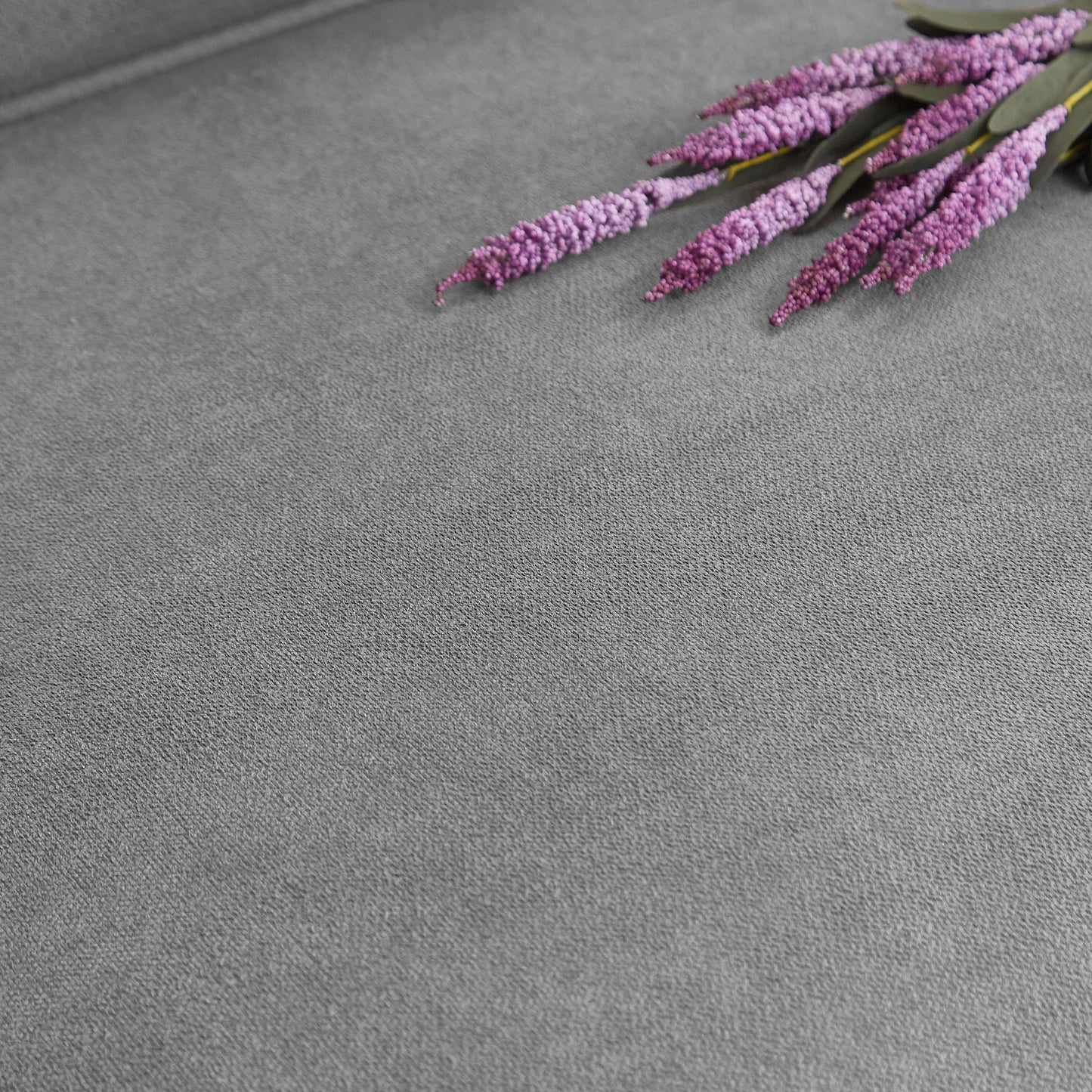 Faux lavender floral bouquet on textured grey background