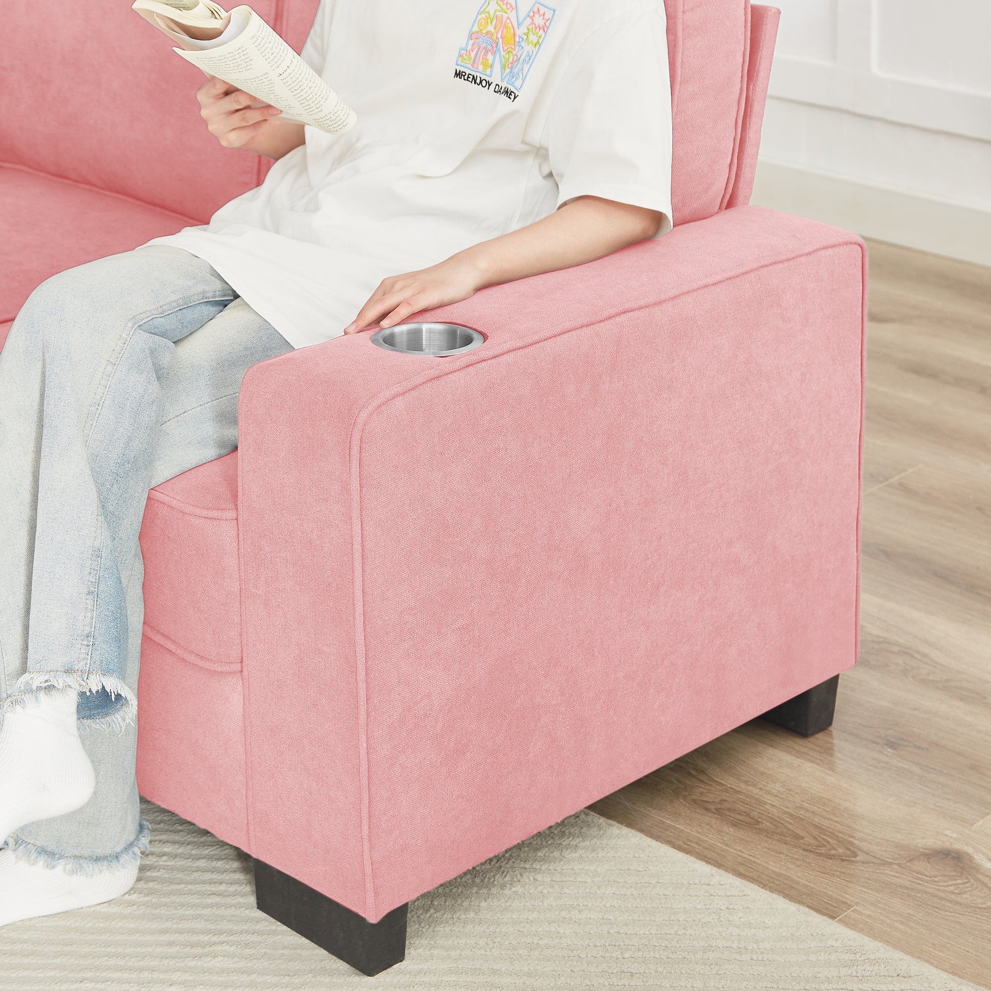 Pink sofa with builtin cup holder and textured fabric upholstery