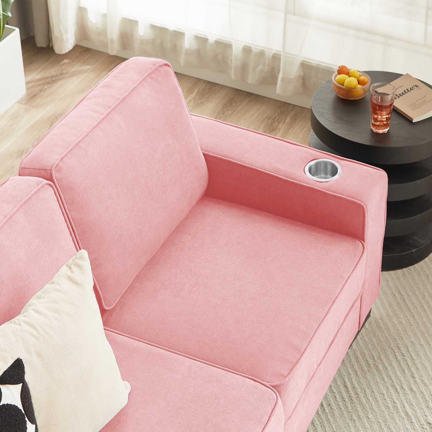 Pink velvet sofa with integrated cup holder