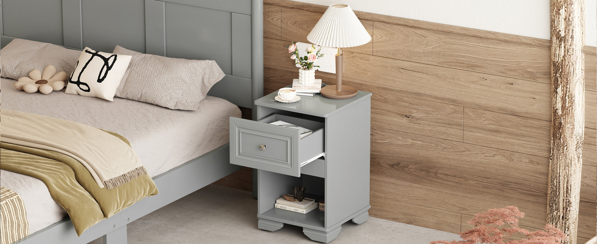Gray wooden bedside table with an open drawer and lamp