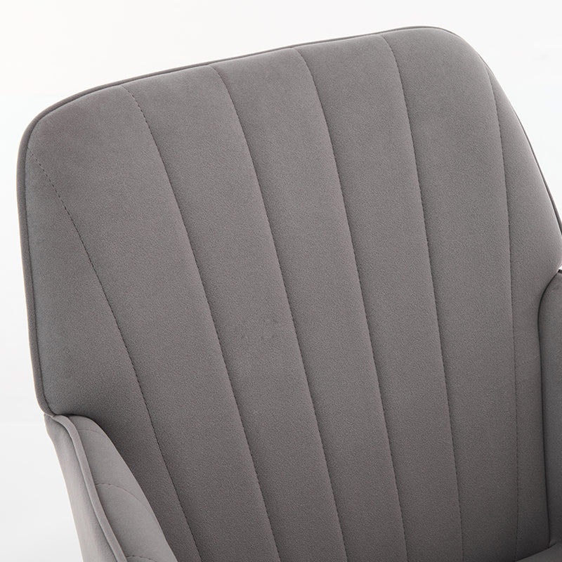 Closeup of a grey velvet accent chair with vertical channel tufting